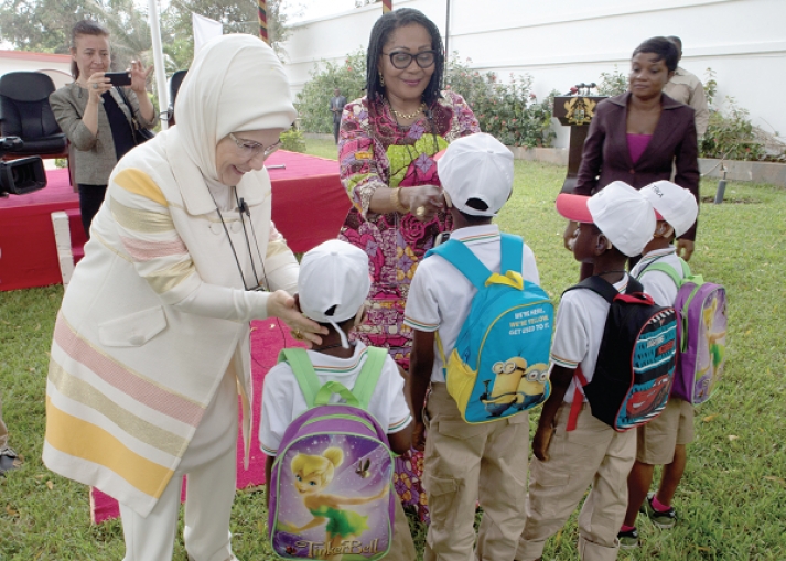 Mrs Mahama and Mrs Erdogan presenting hearing-aid to children of the School of the Deaf