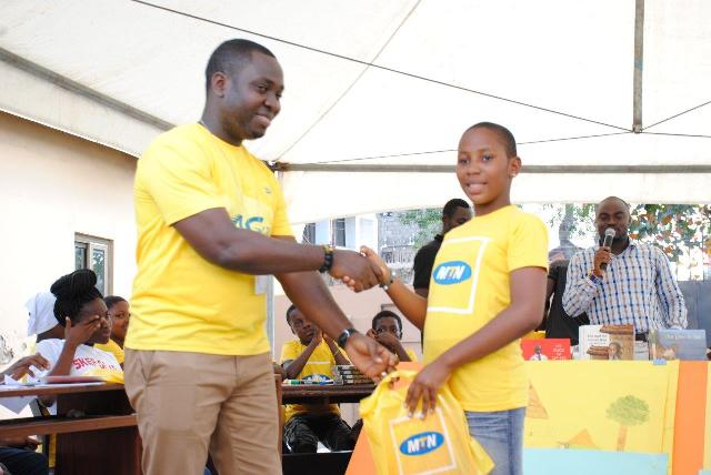 Mr. Ebenezer Terkpeh of MTN Ghana Foundation presenting prize to one of the winners of the reading and spelling competitions