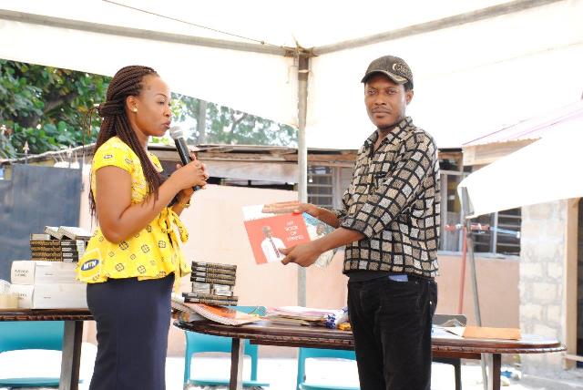 Mrs Rhoderlyn E. Mensa, acting senior manager of the MTN Ghana Foundation presenting the story books and stationary to assistant librarian, Mr. Theophilus Ocquaye