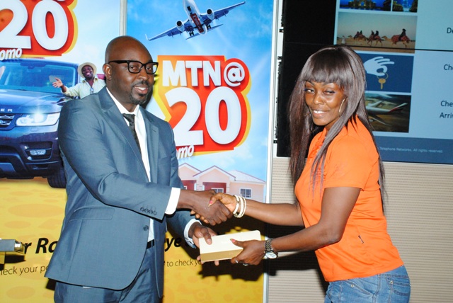 MR. Guido Sopimeh Snr Mgr, MTN Marketing presenting travelling documents to one of teh winners