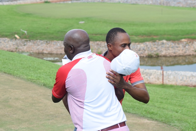 Last year’s winner, Emos Korblah (back facing) gives new winner Vincent Torgah a hug after finishing the 72nd hole